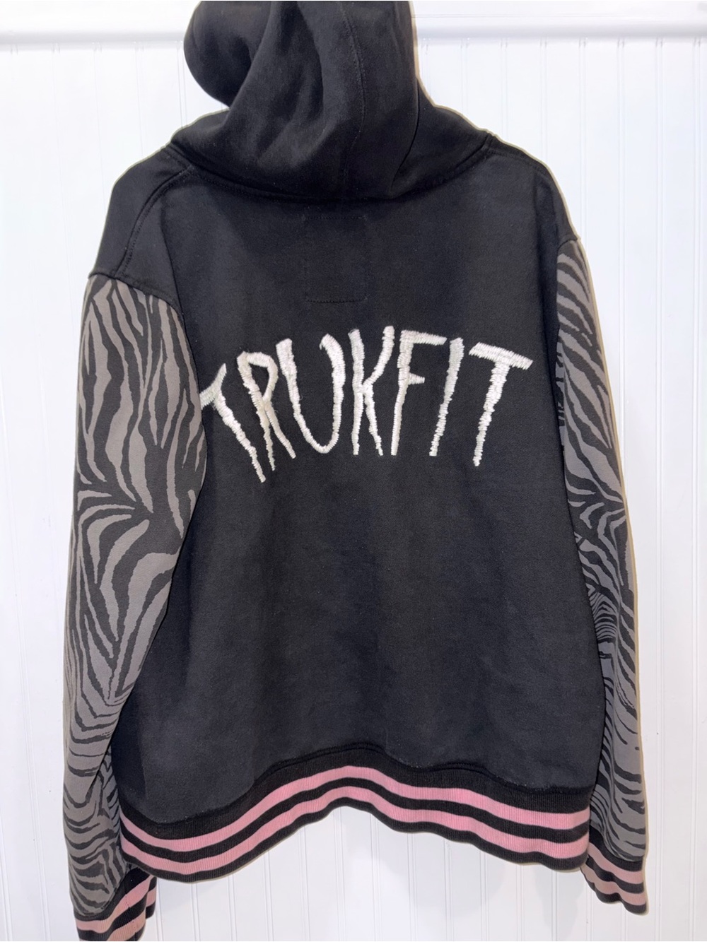 Trukfit Black Hoodie with Zebra-Patterned Gray Sleeves and Pink Trim